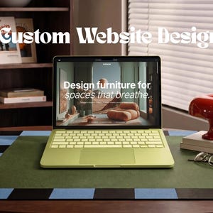 May include: A lime green laptop displaying a website with the text "Design furniture for spaces that breathe." The screen also shows the text "Custom Website Design" above the laptop. A red mushroom-shaped lamp and glasses sit nearby.