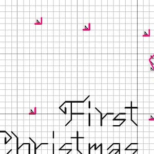 May include: A cross-stitch pattern printed on a white grid background featuring the black text First Christmas. The design includes various symbols such as pink triangles and black plus signs arranged in a grid layout for embroidery guidance.