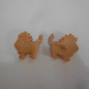 May include: Two brown lion figurines with a simple design. The lions are facing opposite directions.