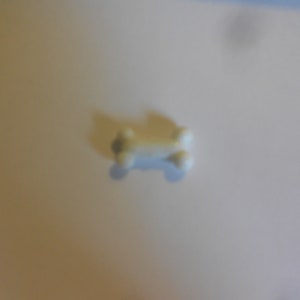 May include: A white plastic dog bone toy.