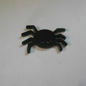May include: A black plastic spider with eight legs and a round body. The spider is a Halloween decoration.