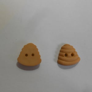 May include: Two brown beehive-shaped buttons with two holes each.