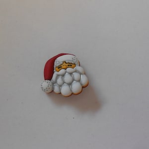 May include: A decorative Santa Claus head with a red hat, white beard, and yellow eyes. The Santa Claus head is a Christmas-themed decoration.
