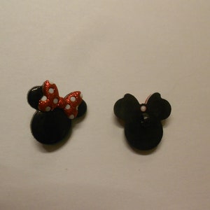 Può includere: Due bottoni neri e bianchi con il personaggio di Minnie Mouse con fiocchi a pois rossi e bianchi.