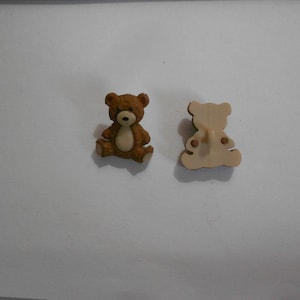 May include: A brown teddy bear button with a beige belly and a beige back. The button is approximately 2.5 cm in diameter.