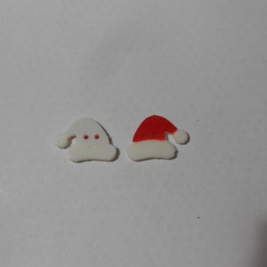 May include: Two white felt Christmas hat ornaments, one with a red felt top.