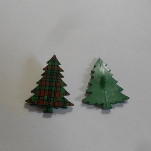 May include: Two Christmas tree buttons, one with a green plaid pattern and the other solid green.
