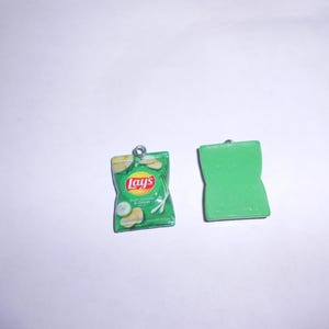 May include: Two green charm pendants, one shaped like a bag of Lay's Sour Cream & Onion potato chips and the other a simple rectangle.