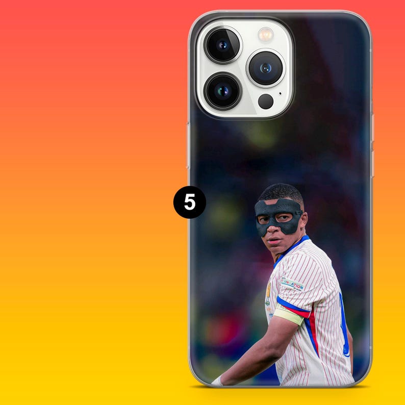 May include: A clear smartphone case featuring a printed image of a football player wearing a black protective face mask and a white pinstriped jersey with blue and red accents. The case has a cutout for a triple-lens camera system and flash.