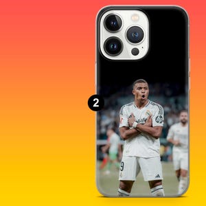 May include: A smartphone case featuring a photographic print of a football player wearing a white Real Madrid jersey with the number 9 on the shorts. The player is standing on a pitch with arms crossed in a celebratory pose. The case has a black top.