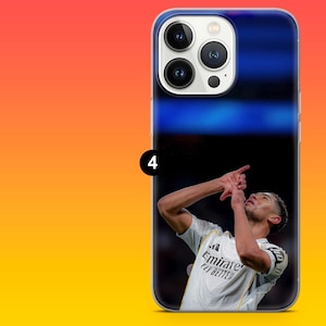 Puede incluir: Una funda para smartphone con una impresi&oacute;n fotogr&aacute;fica de un futbolista con camiseta blanca y el texto Emirates Fly Better, celebrando con los brazos en alto. La funda tiene un recorte para triple c&aacute;mara y un icono negro con el n&uacute;mero 4.