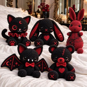 May include: A collection of five handmade crochet plush toys featuring a black cat with a crescent moon, a black and red rabbit, a red rabbit, a black bat with wings, and a black bear with a red heart, all crafted with yarn.