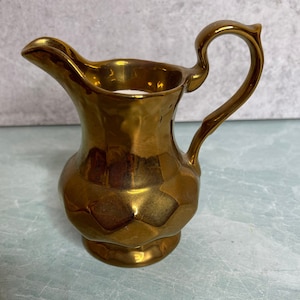 May include: A set of three ceramic mugs with a speckled, matte finish. The mugs are in shades of cream, light gray, and dark gray. Each mug has a simple, minimalist design, perfect for coffee or tea.