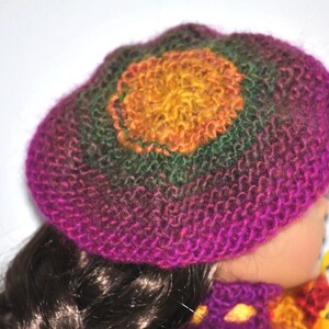 May include: A purple, green, and yellow knitted hat with a crocheted flower design.