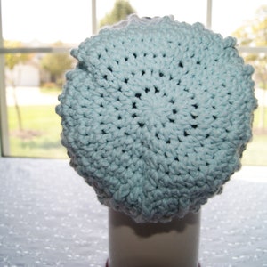 May include: A light blue crocheted beanie hat with a textured pattern.