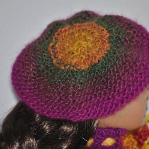 May include: A pink, green, and yellow knitted hat with a flower design. The hat is made of soft yarn and has a comfortable fit.