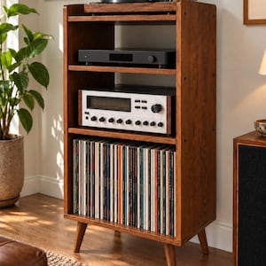 May include: A tall, wooden media storage cabinet with four open shelves. The top shelf holds a record player, the middle shelves house audio equipment, and the bottom shelf contains a collection of vinyl records. It stands on four tapered legs.