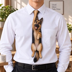 Op de afbeelding: Een wit overhemd met knopen en een stropdas met een realistische, paginagrote grafische print van een Duitse herder. De hond is verticaal afgebeeld en lijkt aan de knoop van de stropdas te hangen.