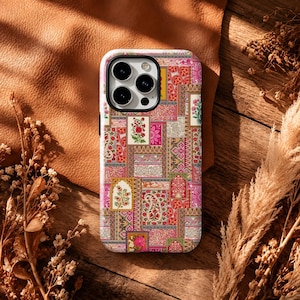 May include: A rectangular smartphone case featuring a vibrant, multi-coloured patchwork design. The pattern consists of various small, intricate rectangular panels displaying floral motifs, paisley shapes, and geometric borders in shades of pink, red, gold, and green.