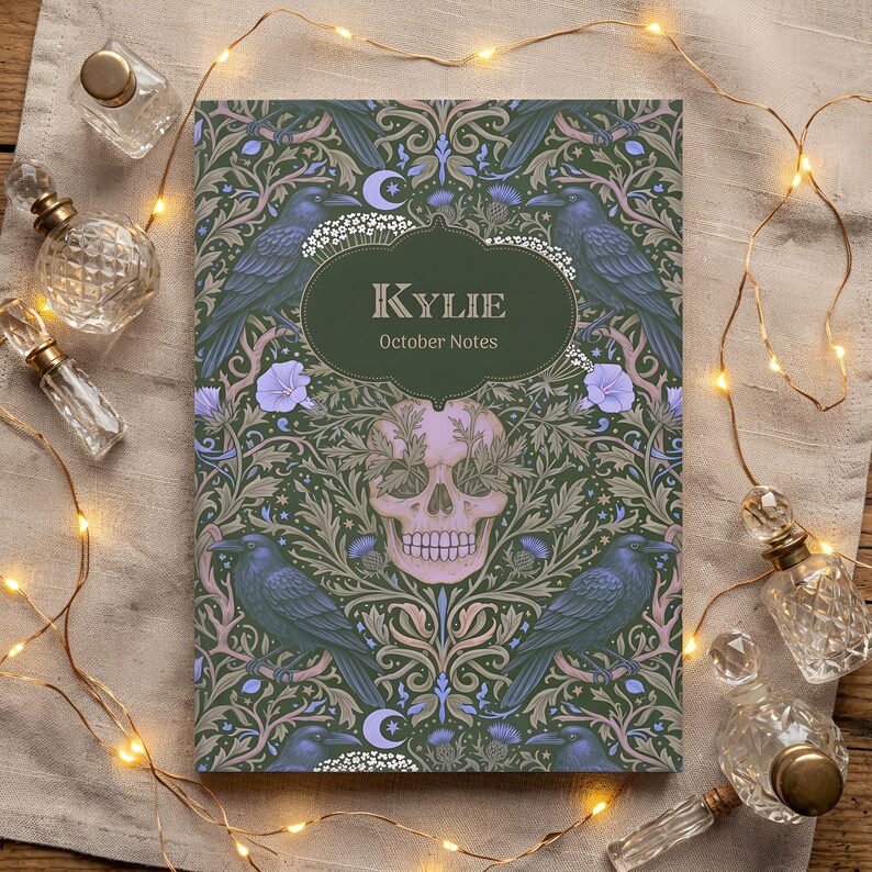 Pu&ograve; includere: Un taccuino rettangolare con copertina verde scuro caratterizzato da un motivo ripetuto di corvi neri, fiori viola chiaro e un teschio rosa pallido centrale. Un'etichetta ovale verde scuro al centro riporta il testo Kylie October Notes.