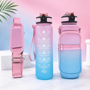 May include: A pink and blue gradient water bottle with a black lid, featuring a time marker scale from 8AM to 7PM with motivational text. It includes a matching pink fabric carrying sleeve with a zippered pocket and a detachable pink shoulder strap.