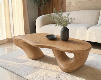 Mesa de centro escultural em madeira maciça, com base curva orgânica e moderna para sala de estar.