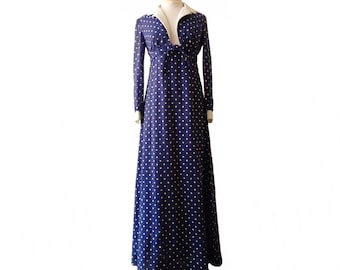 May include: A long, navy blue dress with a white collar and gold polka dots. The dress has a V-neckline and long sleeves.