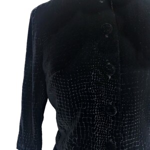May include: A black velvet dress with a textured pattern and button closures.