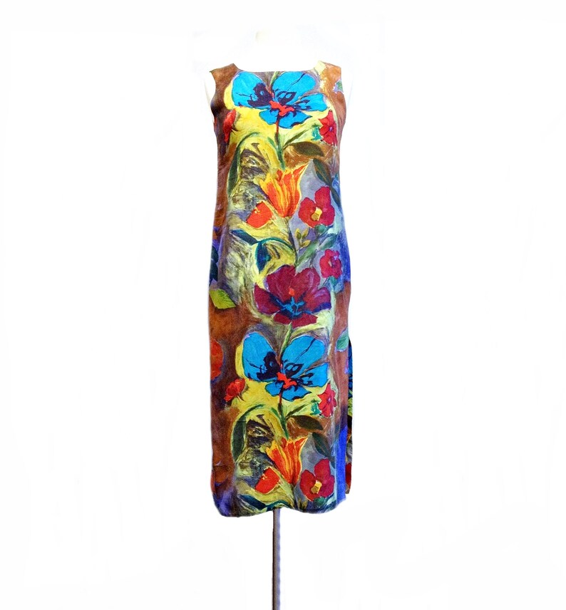 May include: A sleeveless maxi dress with a colorful floral print. The dress features a variety of flowers in shades of blue, red, orange, and yellow on a brown background.
