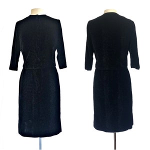May include: A black velvet dress with a textured pattern. The dress has a fitted bodice and a skirt that falls to the knee. The dress has three-quarter sleeves.