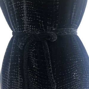 May include: A black velvet dress with a textured pattern and a matching self-tie belt.
