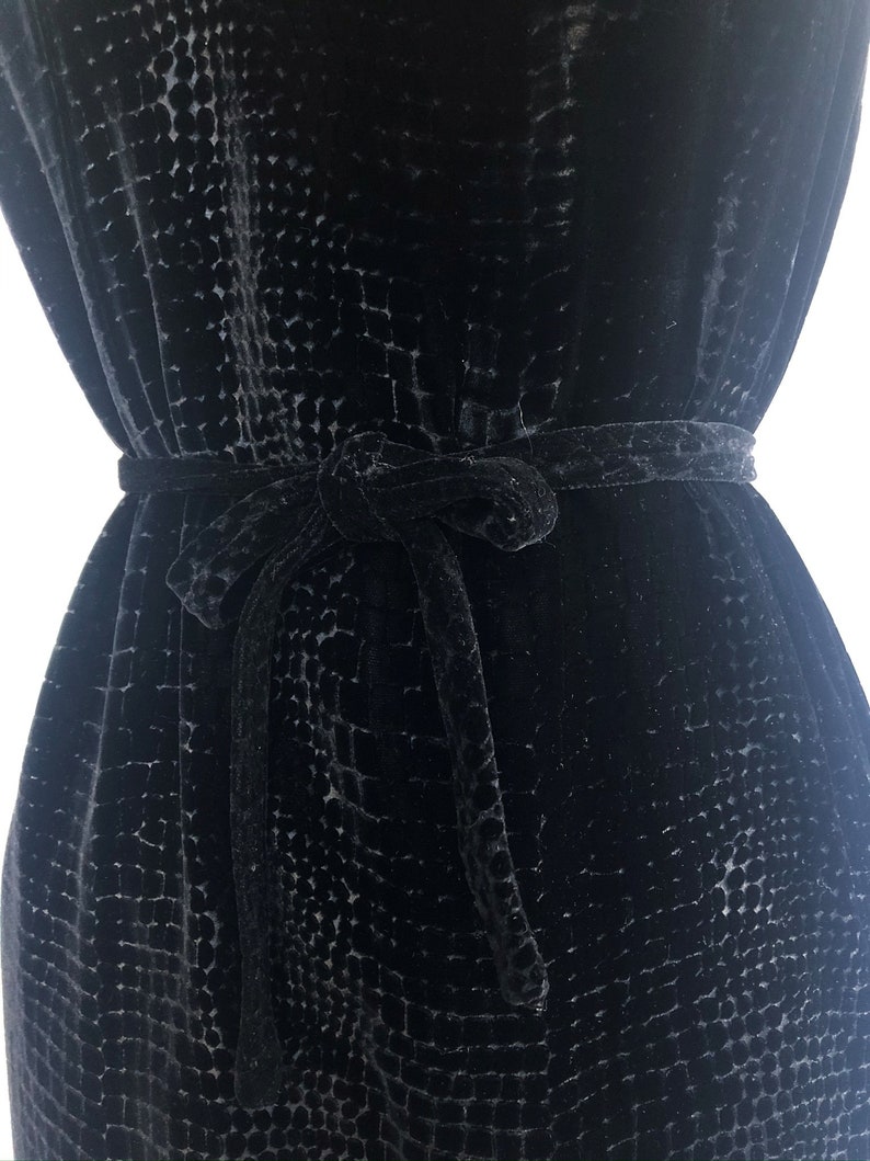 May include: A black velvet dress with a textured pattern and a matching self-tie belt.