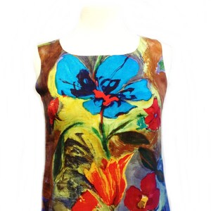 May include: A sleeveless dress with a colorful floral print. The print features large blue, red, yellow, and orange flowers on a brown background.