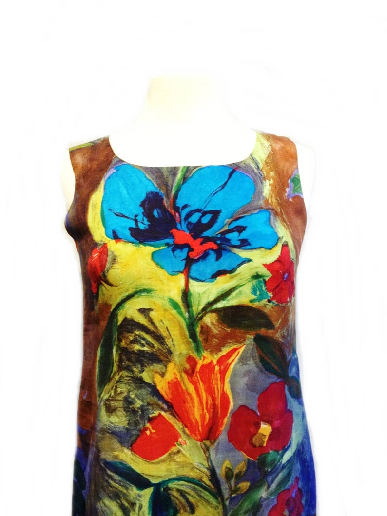 May include: A sleeveless dress with a colorful floral print. The print features large blue, red, yellow, and orange flowers on a brown background.