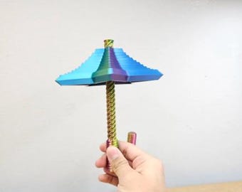 May include: A metallic, iridescent umbrella-shaped object featuring a tiered, square-edged canopy that transitions from blue to purple and green. The central handle is a long, spiraled rod with a matching rainbow-colored, metallic finish.