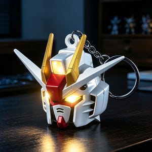 May include: A white, red, and gold robotic head keychain featuring a glowing yellow light in the eyes and forehead sensor. The mechanical head has pointed antennae, a central red crest, and a metal ring attached to the top for keys.