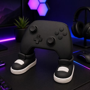 Peut inclure: Un support de manette de jeu vidéo noir mat en forme de paire de jambes portant des baskets noires et blanches. Le support présente une disposition de manette standard avec deux joysticks, une croix directionnelle et quatre boutons.