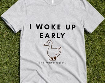 早起きして後悔したアヒルのTシャツ、面白い朝型人間の名言Tシャツ、皮肉な動物グラフィックの眠そうなシャツ