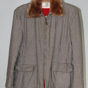 May include: A brown and black plaid jacket with a faux fur collar. The jacket has a zipper closure and two large pockets on the front. The label on the jacket reads "Rellihan".