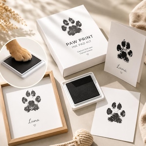 Peut inclure: Un kit de tampon encreur pour empreintes de pattes comprenant une boîte blanche avec le texte noir PAW PRINT INK PAD KIT, un tampon encreur noir carré, un cadre en bois avec une empreinte et le nom Luna, et une carte avec une empreinte.