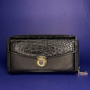Cartera de piel negra con relieve de cocodrilo, monedero con cremallera y cierre de presión dorado.
