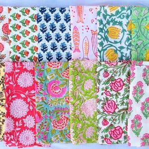Puede incluir: Una colección de dieciséis servilletas de tela rectangulares con diversos patrones estampados en bloque. Los diseños incluyen motivos florales, elementos botánicos y formas de peces en colores vibrantes como rosa, azul, verde, amarillo y naranja sobre fondos blancos.