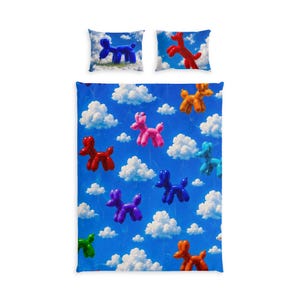May include: A bedding set consisting of a duvet cover and two pillowcases featuring a repeating pattern of colorful balloon dogs in red, blue, pink, orange, and green against a bright blue sky background filled with fluffy white clouds.