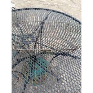 May include: A rectangular wire mesh basket featuring a grid pattern and a weathered, rusted metal finish. The basket has an open top design with thin metal wire construction, showing visible signs of oxidation and age across the entire surface.