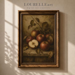Op de afbeelding: Een ingelijste kunstdruk met een stilleven van verschillende rode appels en bladeren op een stenen ondergrond. De tekst LOURELLEart digital art creations is bovenaan zichtbaar. De lijst is donkerbruin met een gedecoreerde rand.