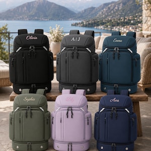 May include: Six backpacks in black, charcoal, teal, olive green, lavender, and navy blue. Each bag features a top compartment with a personalized name or initials embroidered in white, a front zippered pocket, side pockets, and a bottom storage section.