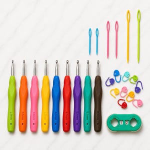 Könnte beinhalten: Ein Set aus neun Häkelnadeln mit farbigen ergonomischen Griffen von 2,0 mm bis 6,0 mm, dazu sechs Kunststoff-Wollnadeln in Blau, Pink und Gelb, zehn verschiedene Maschenmarkierer aus Kunststoff und ein grüner Reihenzähler mit der Anzeige 12.