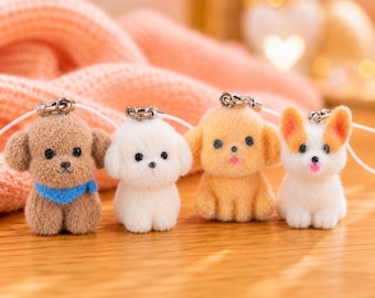 Puede incluir: Cuatro pequeños dijes de perro hechos con fieltro de aguja, que incluyen un cachorro marrón con bufanda azul, un cachorro blanco, un cachorro beige y un cachorro blanco con orejas naranjas. Cada figura tiene ojos de cuenta negra y una argolla.
