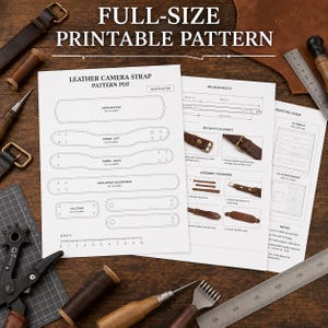 May include: A full-size printable PDF pattern for a leather camera strap on white paper. The document includes outlines for a shoulder pad, tapers, and main straps, along with assembly instructions, buckle placement diagrams, and a 25 cm ruler.
