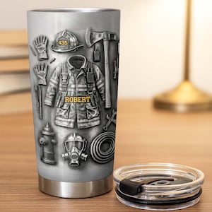 May include: A stainless steel tumbler featuring a graphic print of firefighter gear including a helmet with the number 435, a jacket with the name ROBERT, an axe, gloves, a fire hydrant, a gas mask, and a coiled hose on a metallic background.